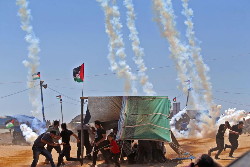  Tear gas falls from the sky as protesters run for cover by the Israeli border in Gaza