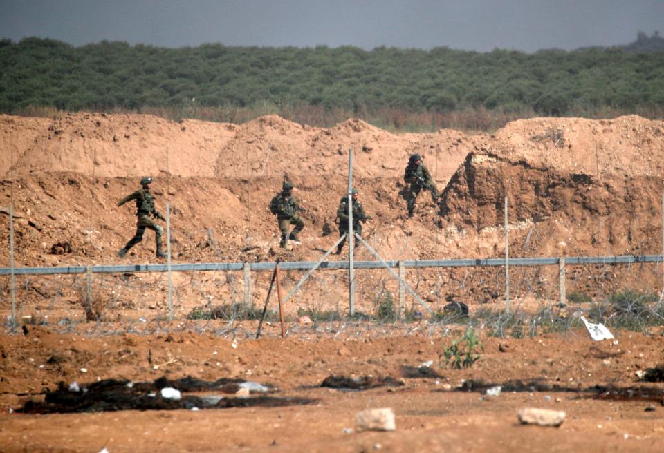  Israeli soldiers take aim at protesters from their positions along the Gaza border