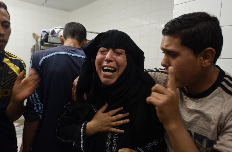  Mourners cry after their relatives were gunned down by Israeli soldiers