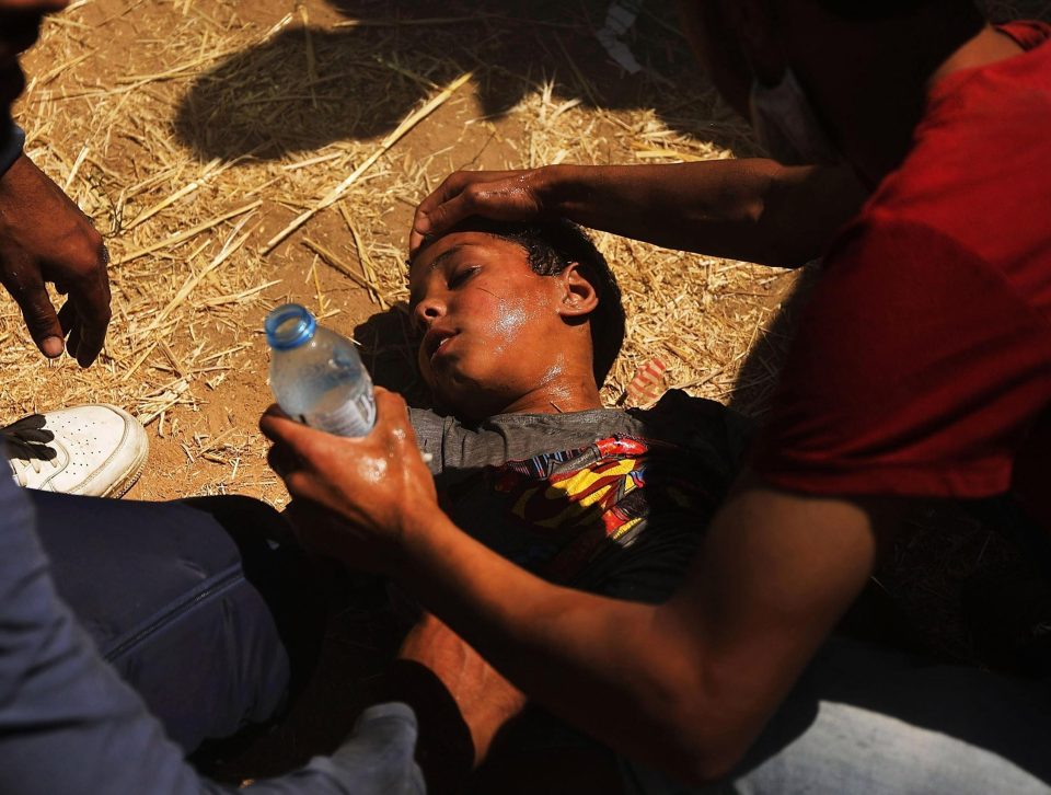  A child overcome by tear gas receives medical help at the border fence with Israel