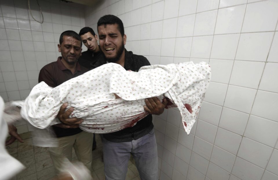  Relatives of one of the victims grieve with the body at a hospital morgue