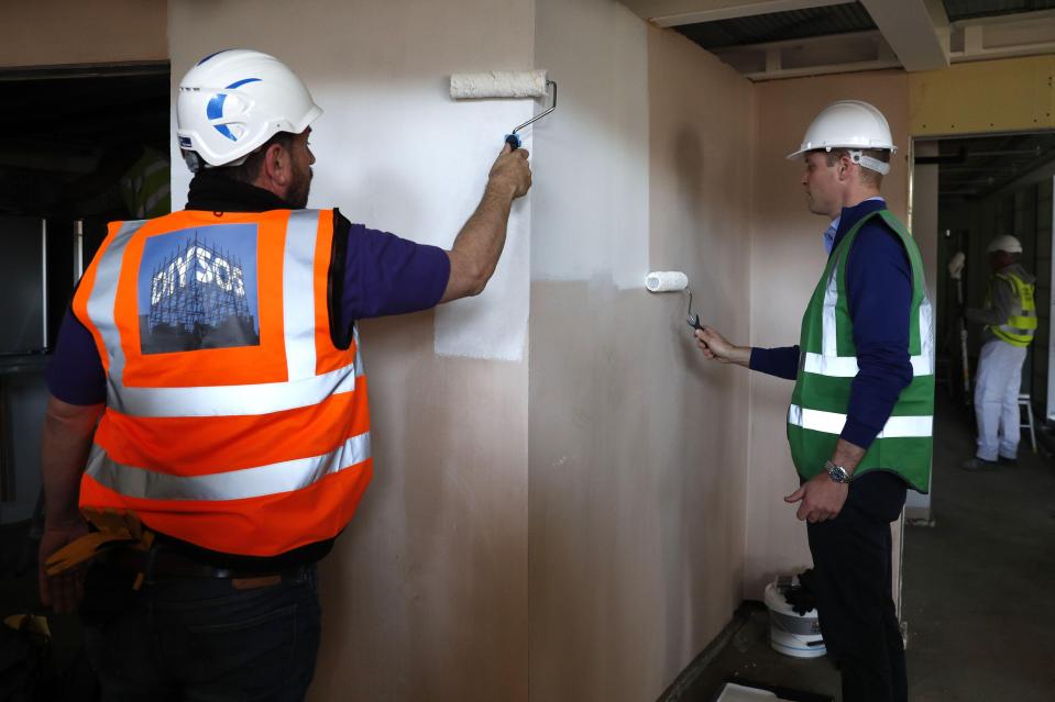  William wore a hi-vis and hard hat as he helped paint a wall