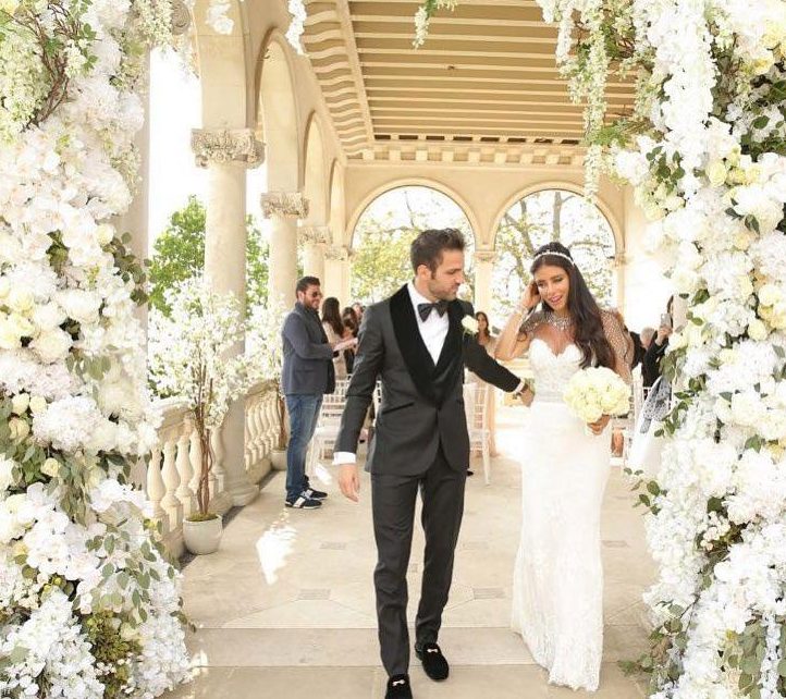  Cesc Fabregas leads Daniella Semaan through an arch of white flowers