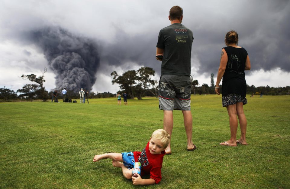  A little boy seems unimpressed by the massive volcanic ash cloud dominating the Hawaiian sky line