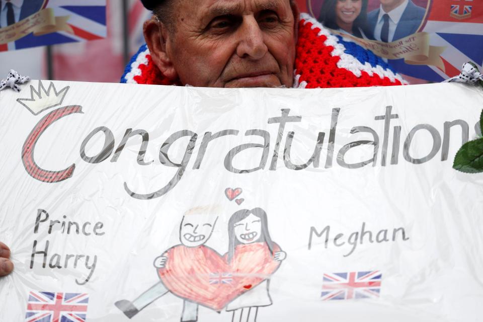  A man holds up a sign to congratulate the couple on their upcoming nuptials