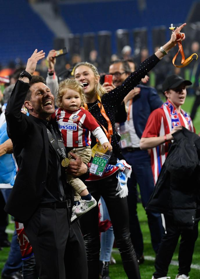  Diego Simeone and Carla Pereyra point to the fans with baby Francesca