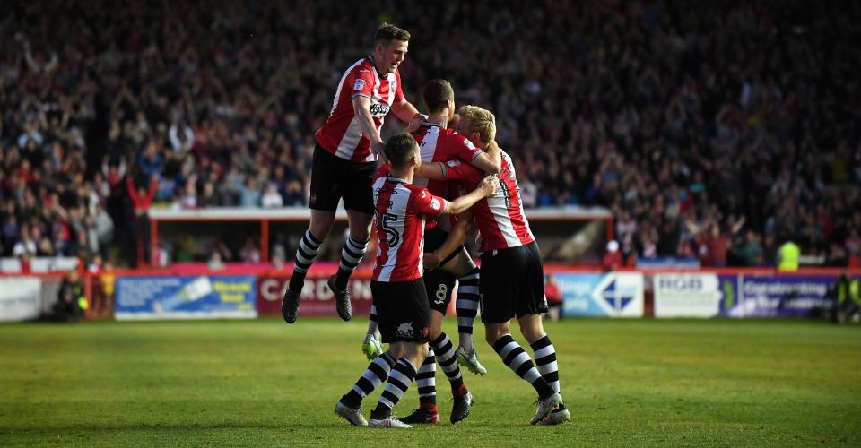  Ryan Harley is mobbed after scoring Exeter's third goal