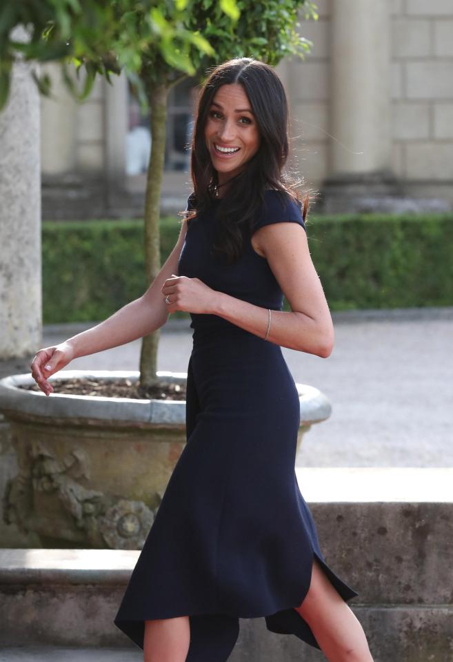  Meghan Markle walks into her hotel to prepare for the Royal Wedding and smiles after announcing Prince Charles will walk her down the aisle