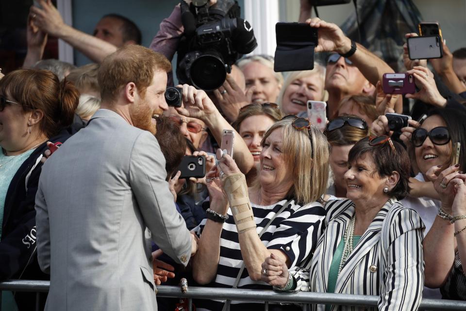  Prince Harry cracks a joke and smiles with well-wishers as they crowd round for photos of the royal groom