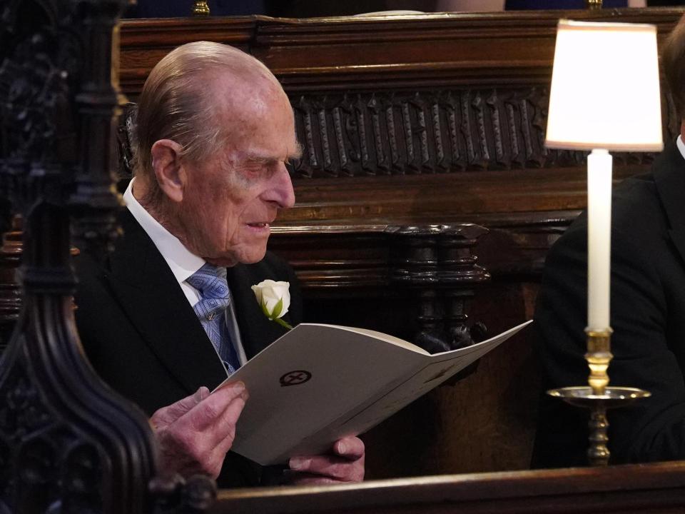  The Duke Of Edinburgh leafs through the order of service ahead of Harry's wedding