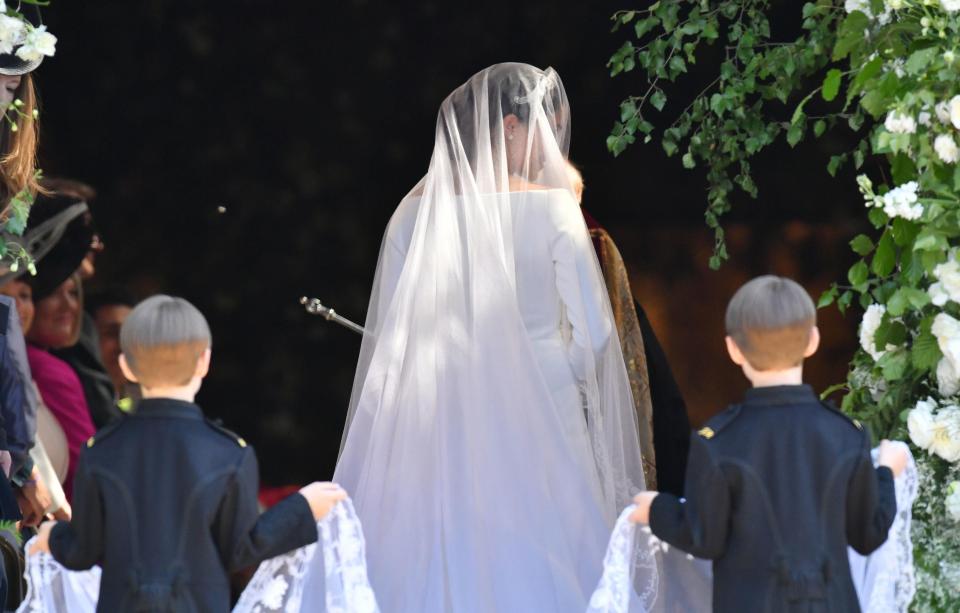  Meghan's dress scooped boat neck, with a flowing train and extra long veil