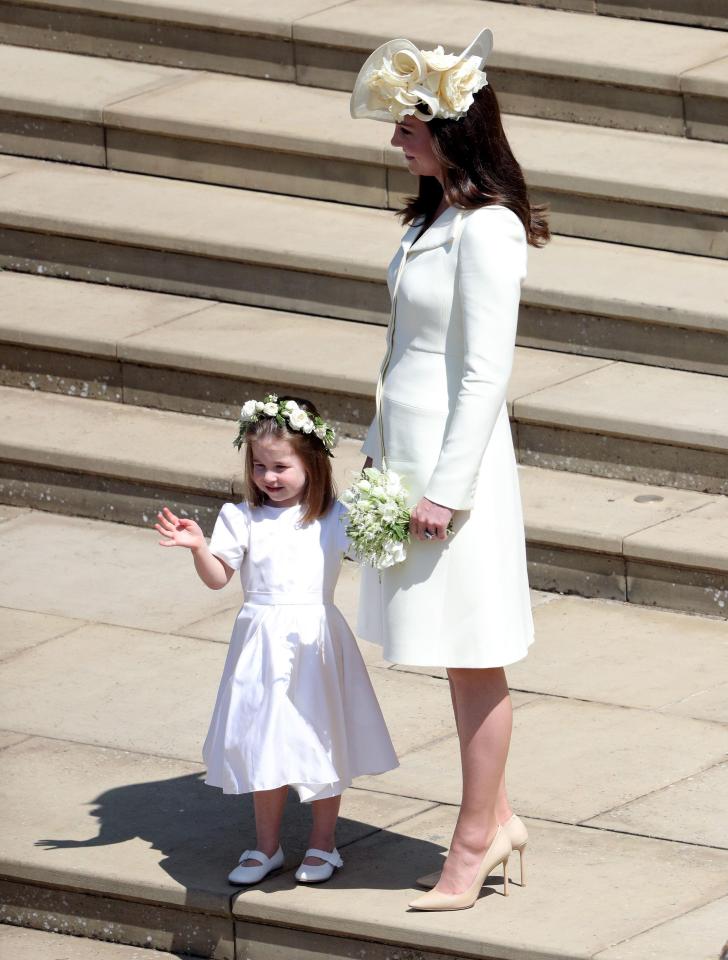  The adorable tot clings on to mum Kate Middleton's hands following the ceremony