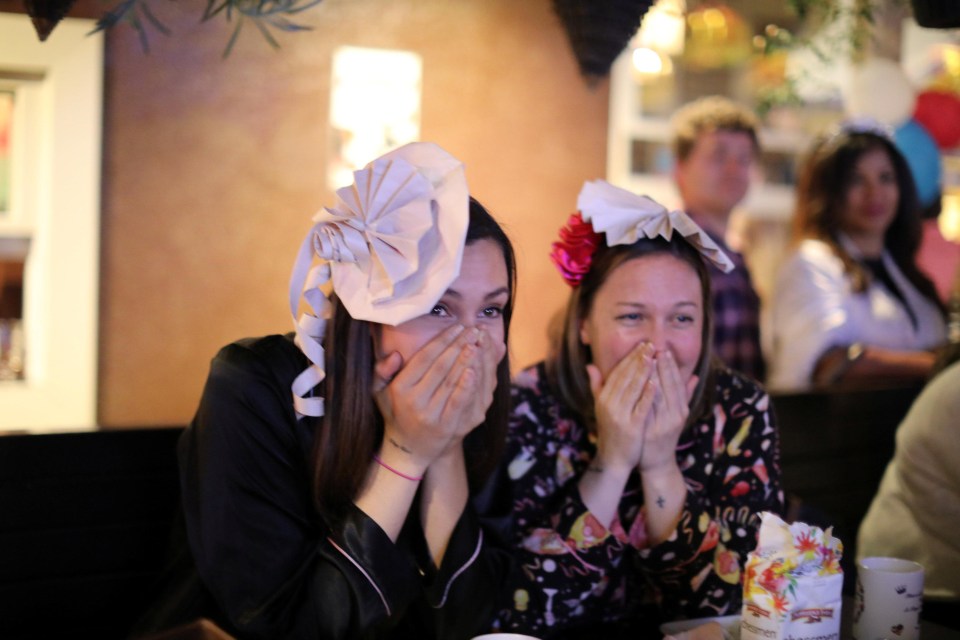 Two excited women with fascinators watch the Royal Wedding from the Cat & Fiddle Pub in Hollywood