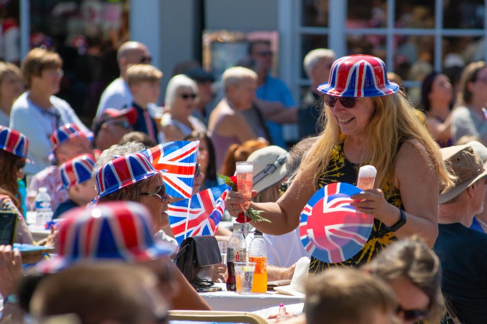 Union jack flags and hats make a big show as royalists gather at a street party in Hampshire