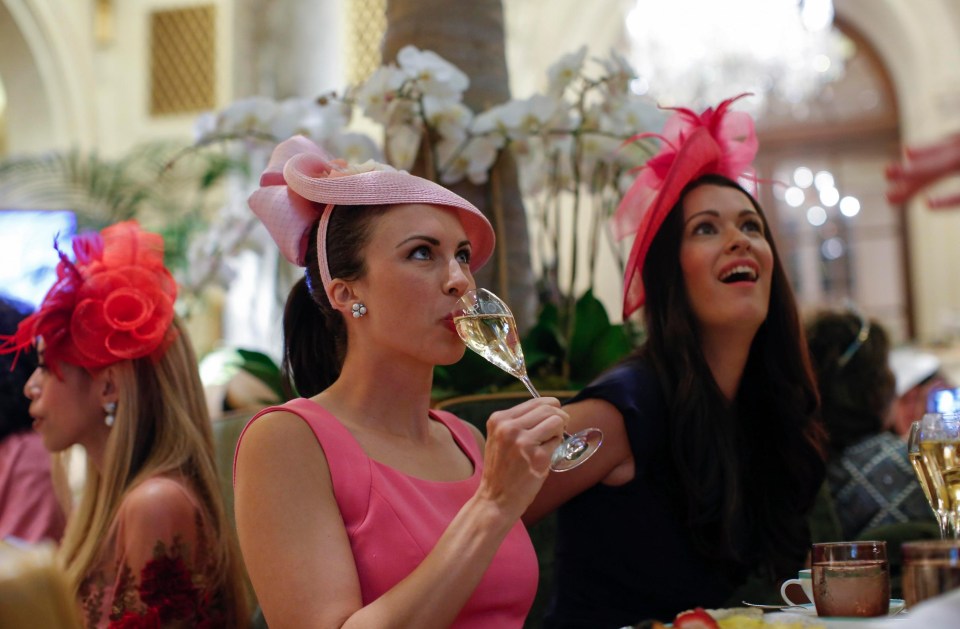 A lady in pink sips champagne as she watches the ceremony from New York