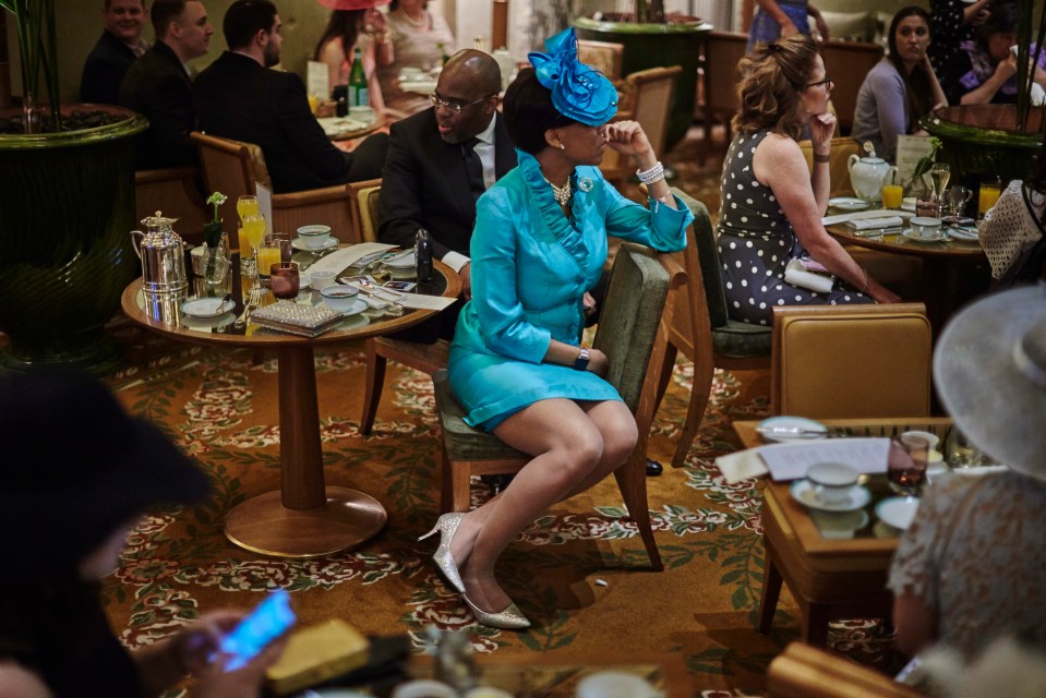 A Royal Wedding watcher in a stunning blue outfit and fascinator watches the nuptials from New York