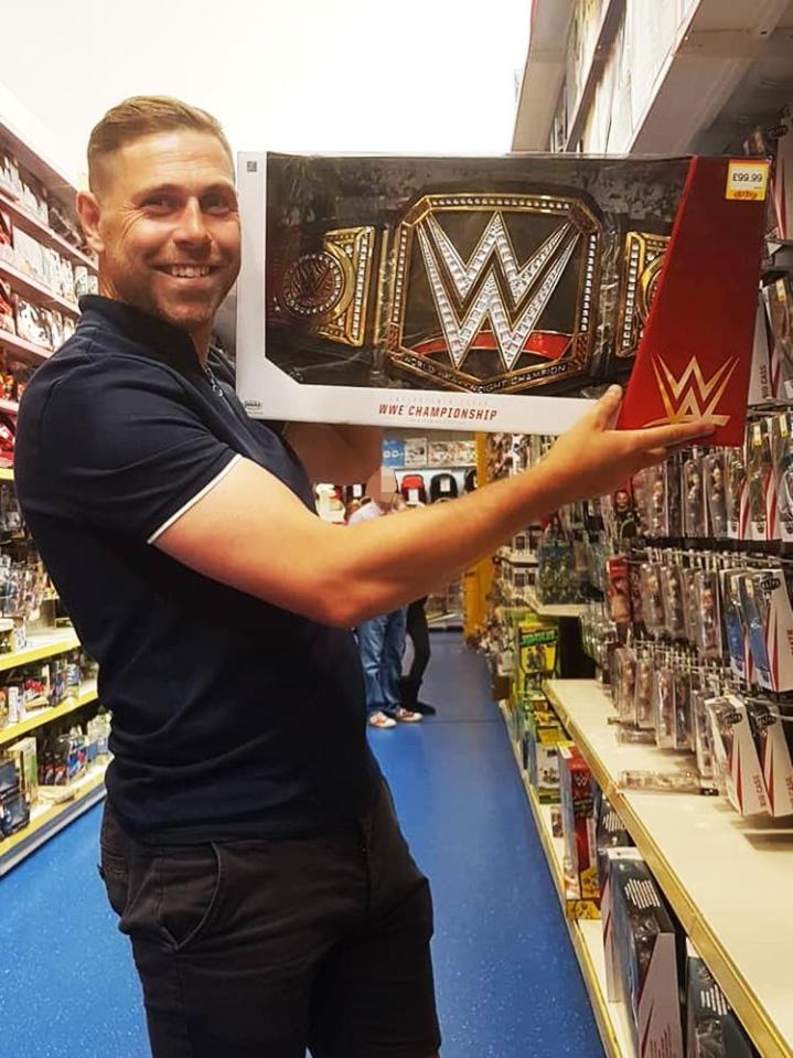  Grant Holt holding up a you WWE world title belt in a shop as he is set to join the wrestling world