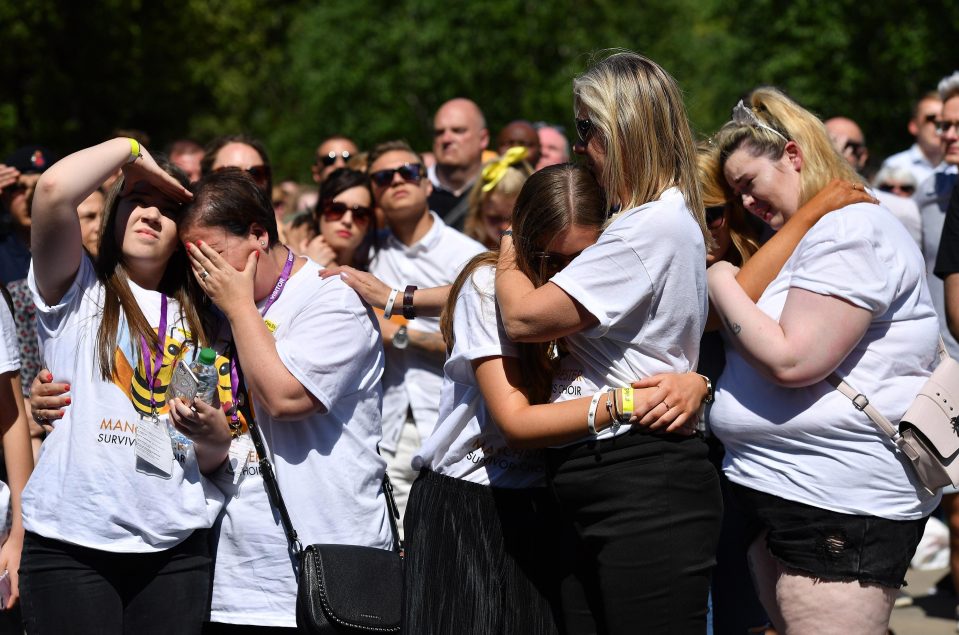  Weeping girls embrace each other as a minute's silence is held