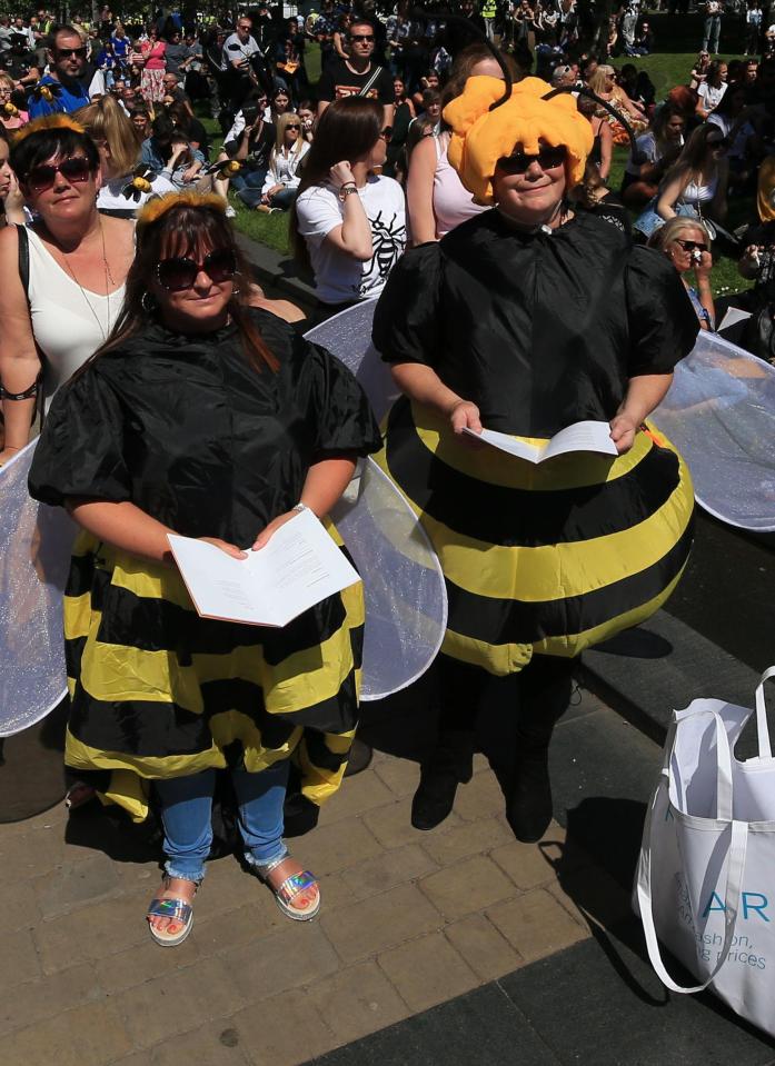  Two women dressed in bee costumes pay their respects in Manchester today