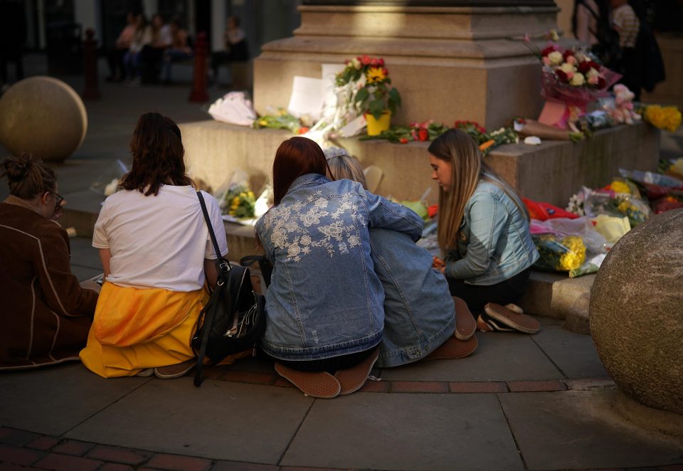  Teenage girls sing Ariana Grande songs near floral tributes, in St Ann's Square