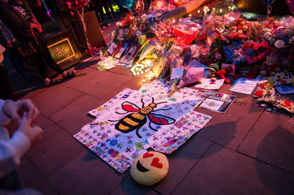  Tributes piled up in the square as hundreds came to pay their respects