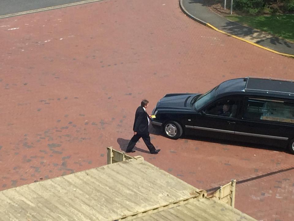  The stunned funeral driver is then seen walking towards his accompanying hearse