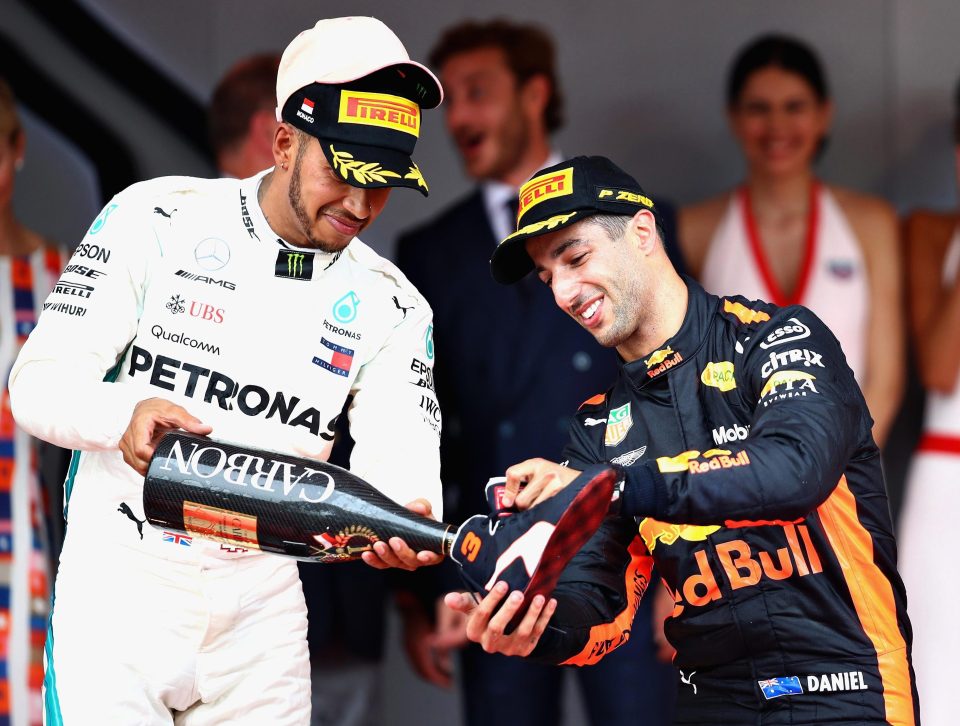  Race winner Daniel Ricciardo of Australia and Red Bull Racing celebrates on the podium with a shoey poured by Lewis Hamilton