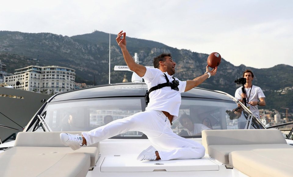  Daniel Ricciardo tries to catch a pass from NFL star Tom Brady after his win