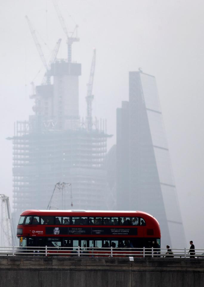  A double decker bus drives through the rain across Waterloo Bridge