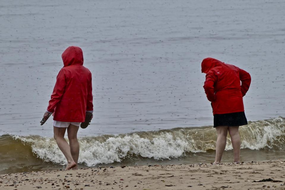  Some people look out into the water, perhaps dreaming of a more sunny day