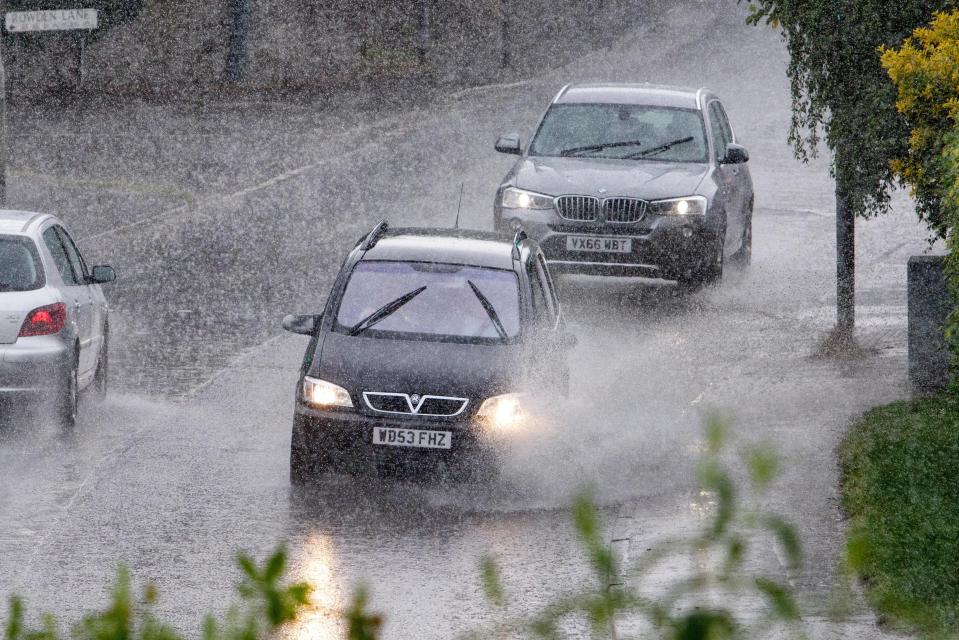  Cars drive through torrential rain in Chippenham,Wilts., on Thursday as amber weather warnings are issued for the country