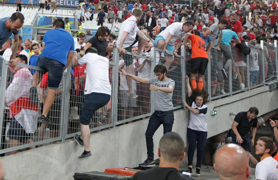  Fans try to escape from Russian supporters who went on a charge in the stands right after the Euro 2016 Group B soccer match between England and Russia