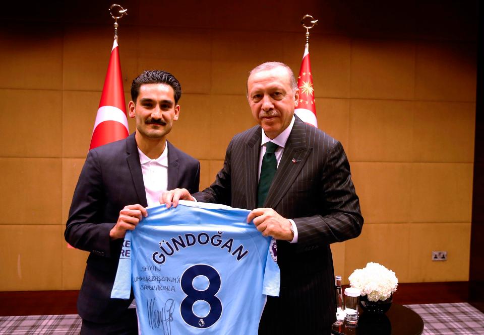  Turkish President Recep Tayyip Erdogan (R) posing for a photo with Turkish football players Ilkay Gundogan (L) in London