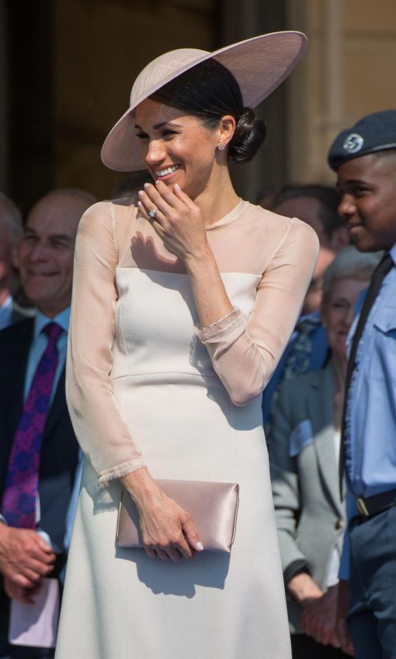  Meghan Markle made her first post-wedding appearance at the a Buckingham Palace garden party for the Prince of Wales' 70th birthday, carrying a pink clutch