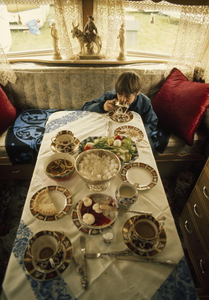  A young boy tucks into some food and drink during a break from the festivities in the 1970s