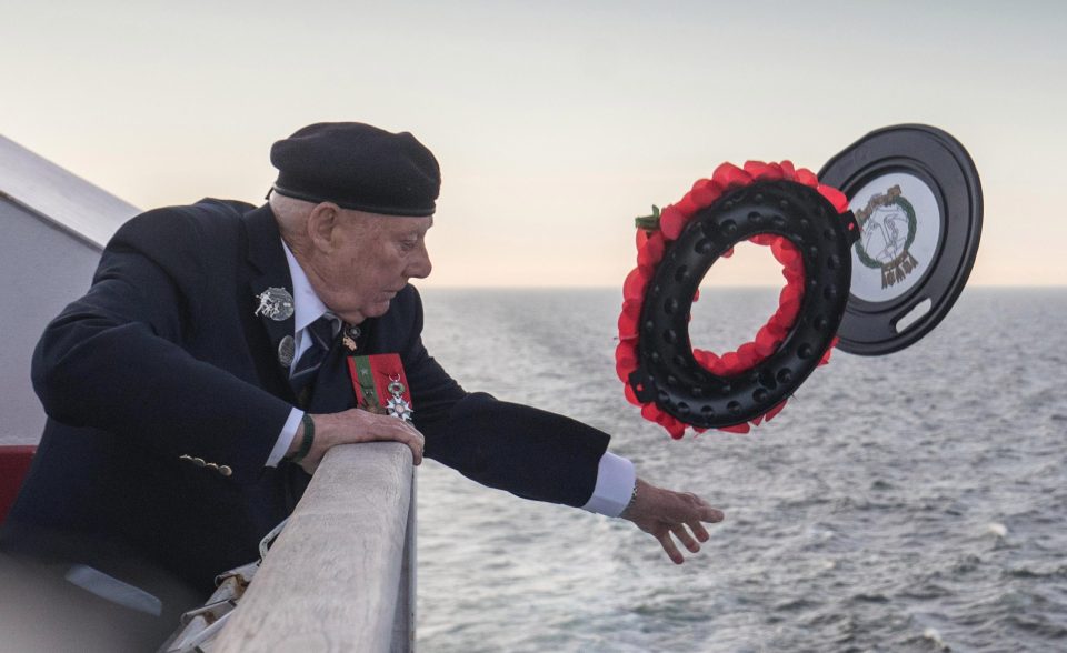  Royal Marine John Quinn throws a wreath from the deck of the ferry into the sea