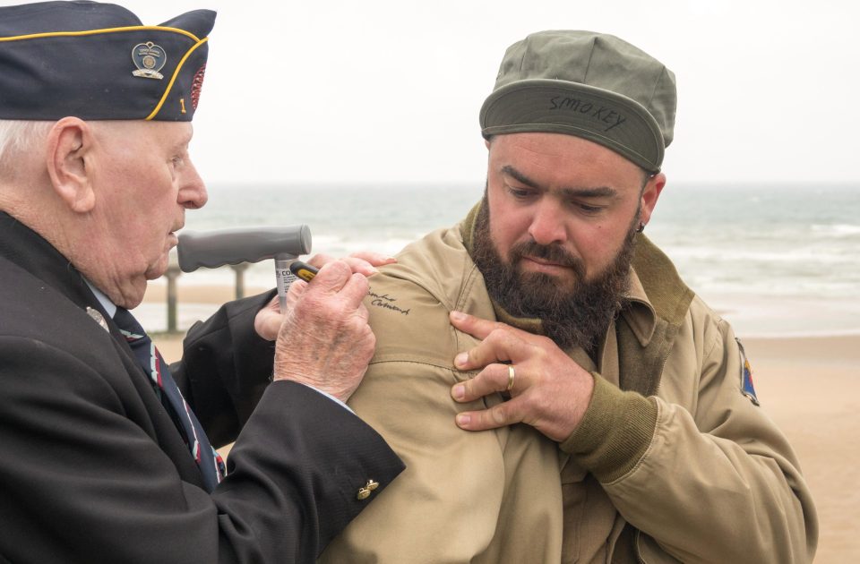  A veteran signs a World War 2 re-enactor's uniform at the wreath laying ceremony