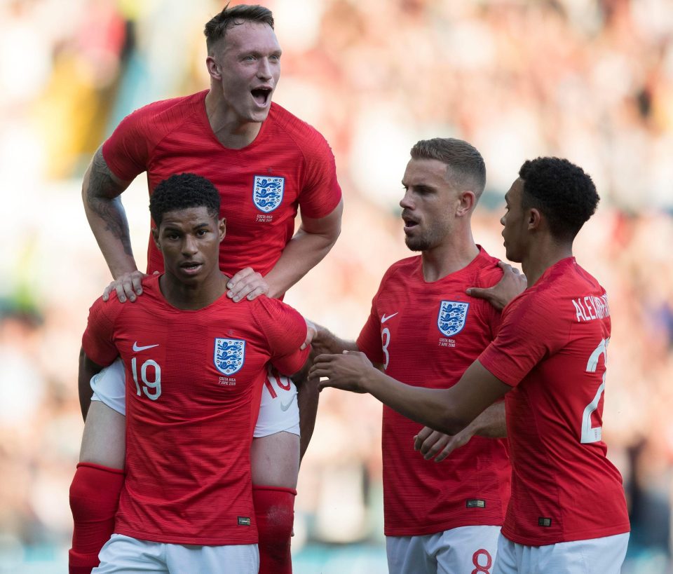  Rashford is mobbed by his England team-mates after his stunning goal fired them ahead at Elland Road