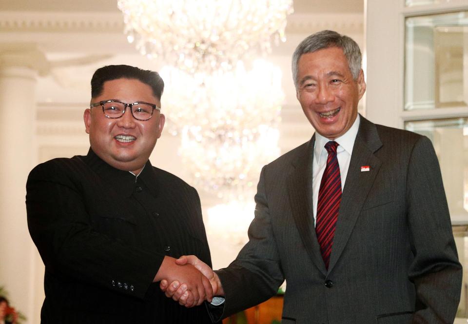  Kim shakes hands with Singapore's Prime Minister Lee Hsien Loong