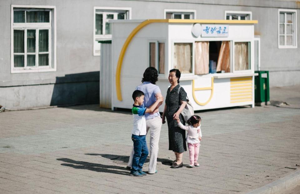  Two women and two shy children stop for a chat in North Korea