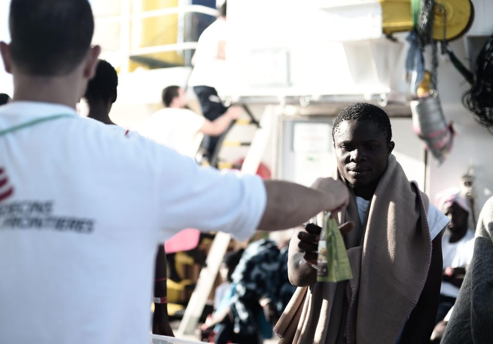  A migrant on board the French rescue ship Aquarius, stranded at sea for almost two days, is served food from a Doctors Without Borders worker