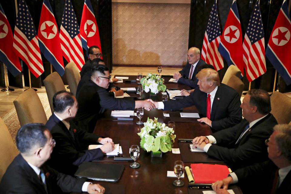  Trump and Kim shake hands across a grand table after their 51-minute one-to-one conference