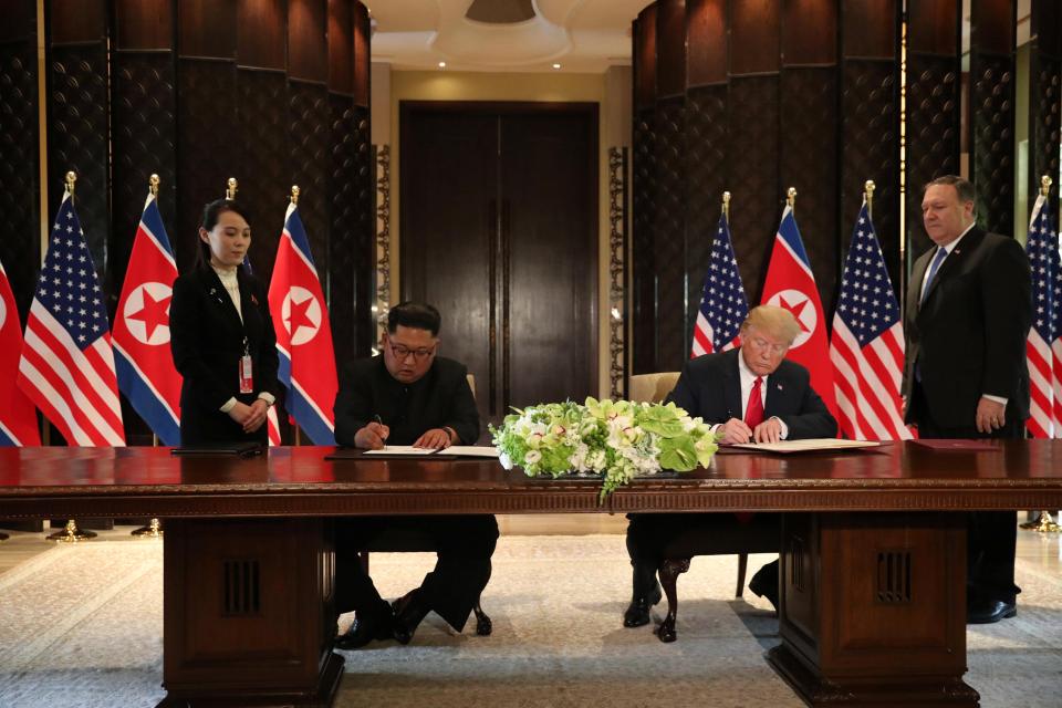  Trump and Kim sign the agreement during a ceremony in Singapore