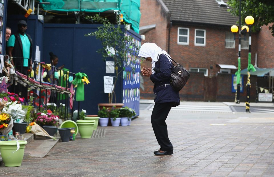  A woman pauses to reflect during the one year anniversary of the Grenfell Tower fire