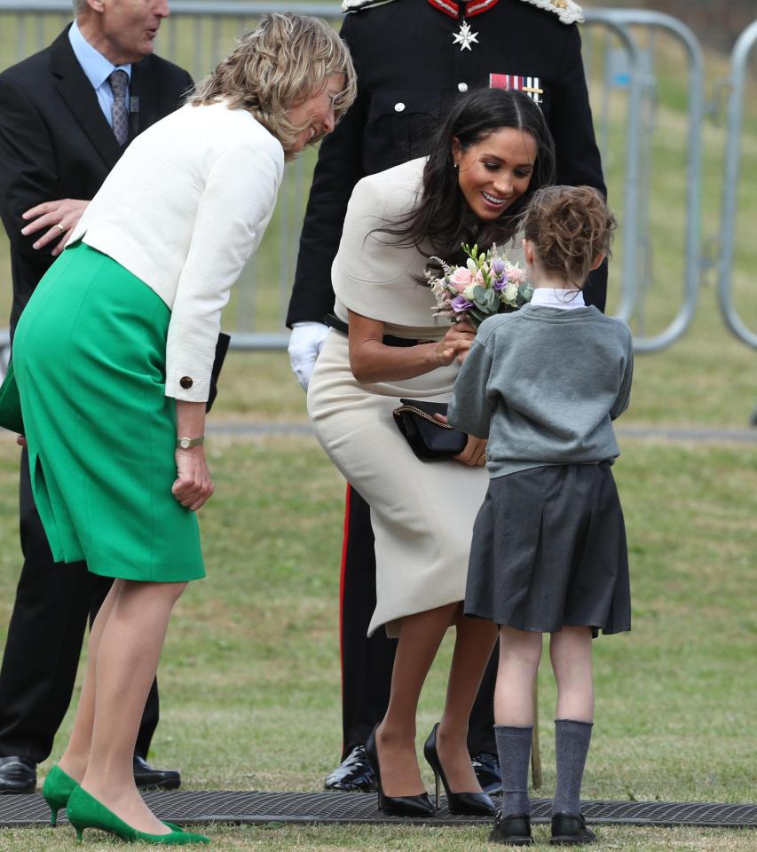  Meghan seemed delighted as she was given some flowers on her arrival