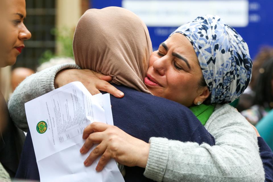  Two friends hug as bereaved families and members of the community pause to reflect on the one-year anniversary of the tragedy