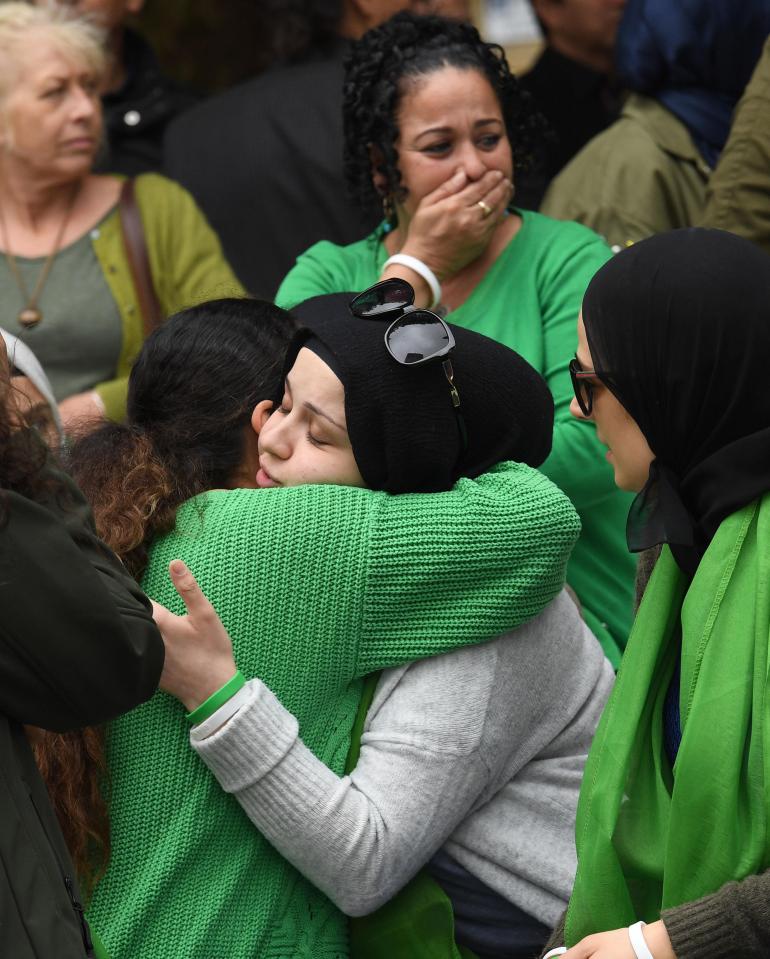  Two friends embrace as people arrive for the Grenfell Tower anniversary national minute silence