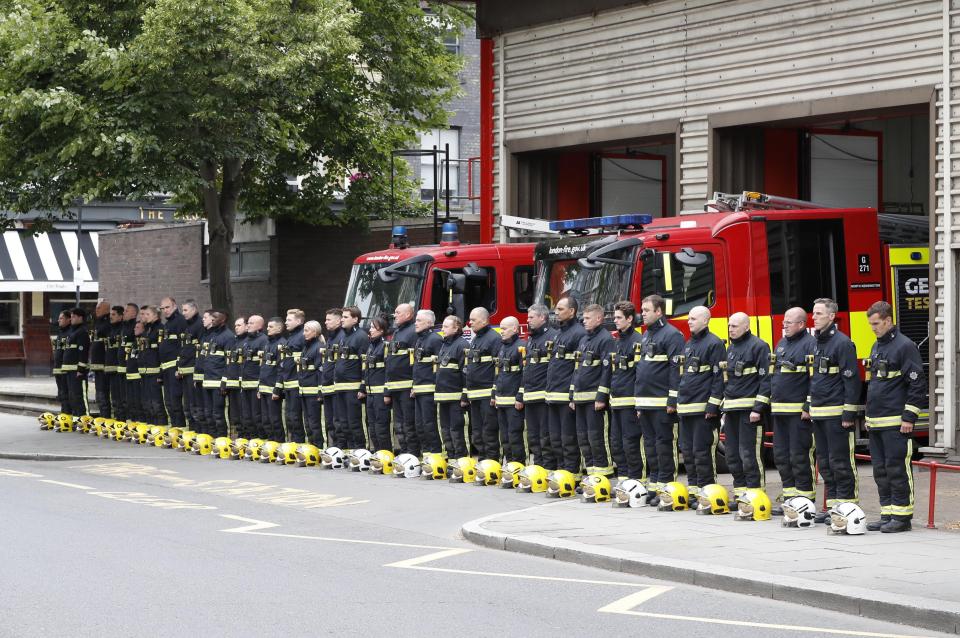  ire fighters from the fire stations of North Kensington, Chelsea and Kensington stand during a minute's silence in memory of the victims of the fire