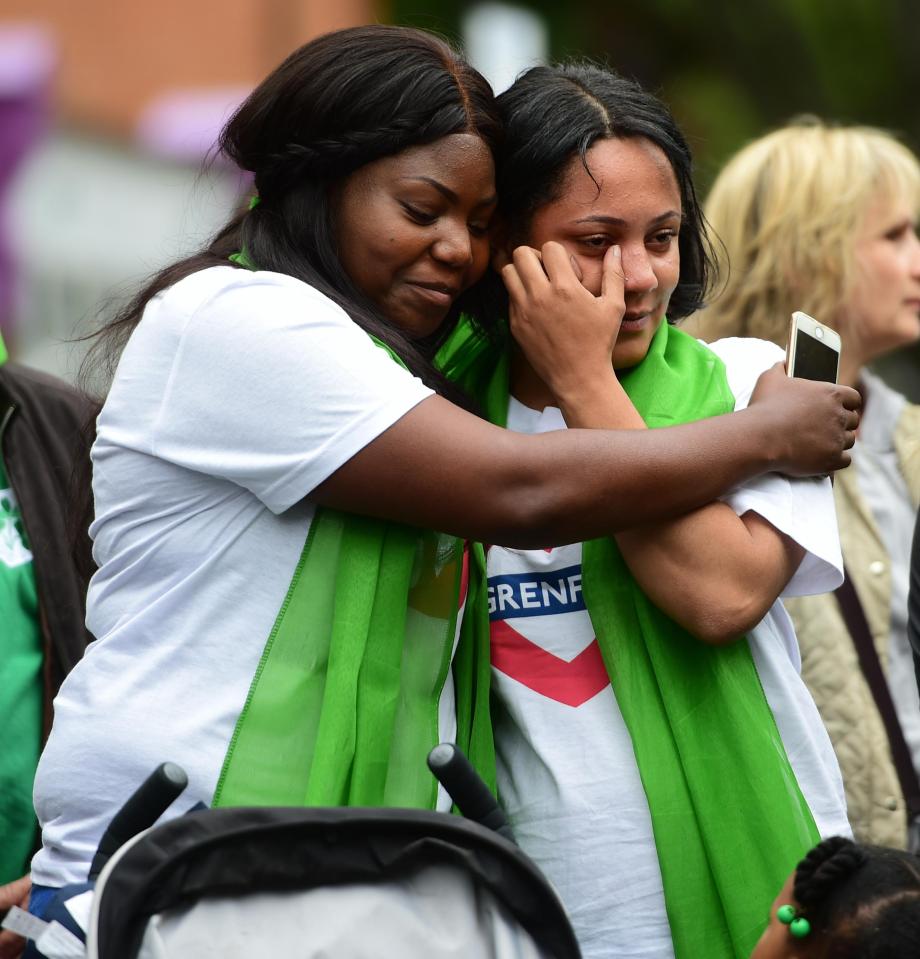  A woman consoles her friend on the anniversary of the devastating fire in west London