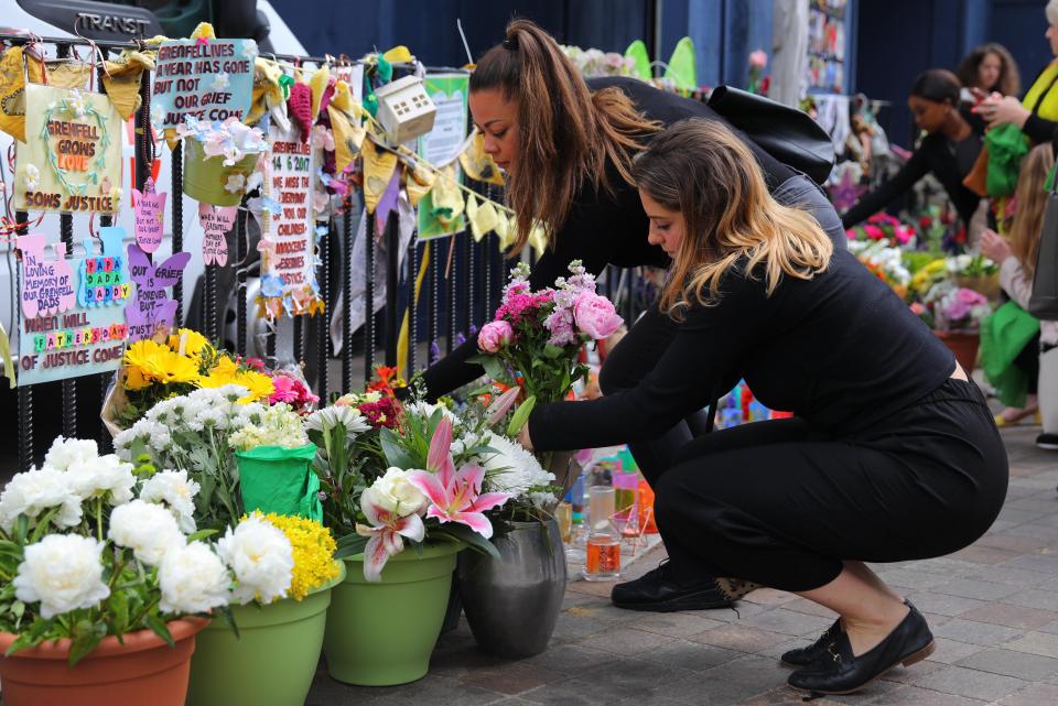  A woman pays her respects to the victims of the tragedy that claimed the lives of 72 people